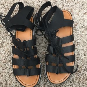 Black flat lace sandals.